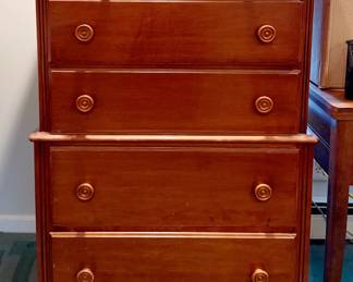 This is a vintage solid hard rock maple highboy chest that features a two-section chest-on-chest build, round wooden pull knobs, and dovetailed drawers.