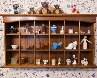 wall shelf with various glass hats, shoes and figurines
