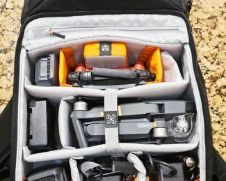 DJI Mavic Pro Drone Package DJI Mavic Pro foldable camera drone, Model M1P, complete with DJI remote controller and Lowepro padded carrying backpack. Package includes multiple DJI Intelligent Flight batteries, battery charging equipment, cables/power accessories, controller, and other accessories shown. Features a stabilized gimbal-mounted camera, GPS-assisted flight, compact folding design, and app-based flight controls.