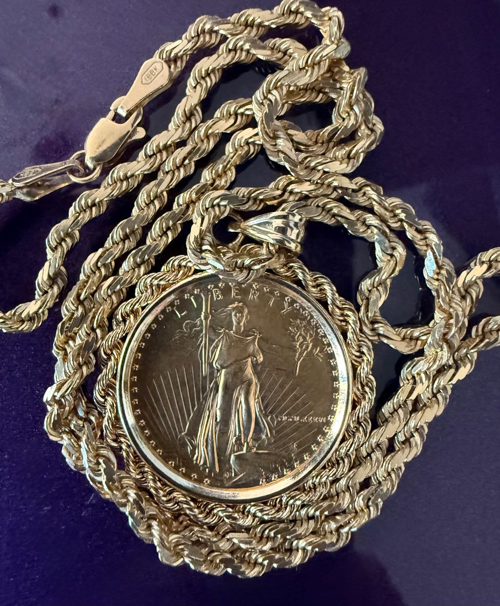 14K yellow gold rope chain necklace featuring a U.S. American Eagle gold coin pendant.Pendant: Features a Lady Liberty design from an American Eagle coin.Bezel: The coin is set in a 14K yellow gold classic bezel.Necklace: A braided rope chain necklace is attached to the pendant. Weight is 24 grams
