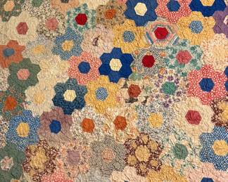 Exceptional 1930s "Grandmother’s Flower Garden" Hand-Pieced Quilt (72” x 62”)Description: A stunning example of an all-over mosaic hexagon quilt dating to the late 1930s/early 1940s. Features hundreds of tiny, hand-pieced hexagons using a vibrant array of authentic Depression-era calico, dot, and floral dress-scrap fabrics. Completely hand-quilted with incredibly tight, precise needlework outlining the floral clusters. Features the highly desirable finished scalloped edge.Size: 72” x 62” (Ideal large twin size or expansive display throw).Condition: Excellent collector grade. Structurally pristine with no fraying, no torn seams, no fabric shredding. Tight, strong stitching throughout. Backed in plain white muslin showing only , age-appropriate fabric pilling.