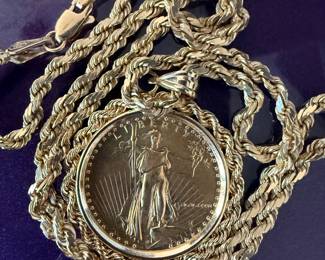 14K yellow gold rope chain necklace featuring a U.S. American Eagle gold coin pendant.Pendant: Features a Lady Liberty design from an American Eagle coin.Bezel: The coin is set in a 14K yellow gold classic bezel.Necklace: A braided rope chain necklace is attached to the pendant. Weight is 24 grams