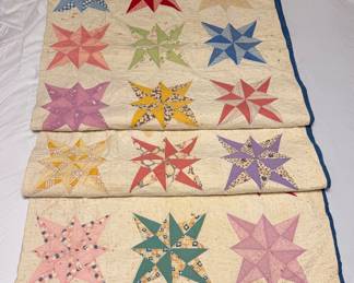 Vintage 1930s "LeMoyne Star" Patchwork Quilt (Ohio/PA Family Origin)Description: A charming Depression-era scrap quilt featuring hand-pieced eight-pointed "LeMoyne Star" blocks. Showcases a wonderful array of authentic 1930s pastel florals, checks, and calico dress prints framed by a solid deep-blue edge binding. Completely hand-quilted with traditional linear and echo stitching patterns. From a family lineage originating in the Ohio/Pennsylvania quilt belt.Condition: Fair to Good vintage condition. Fabric and hand-stitching remain strong and structurally sound. Shows visible scattered age spots, storage foxing, and light staining on the cream muslin ground consistent with age. Perfect as a rustic display piece, cutter quilt project, or for a collector skilled in vintage textile restoration.