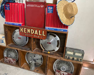 Lot 7: Vintage automotive parts display with Kendall oil sign and hubcaps