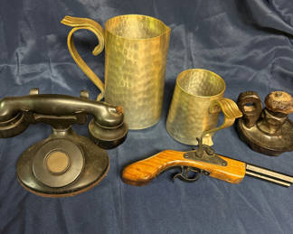Lot 221: Antique hammered metal pitchers, a vintage black telephone device, and a wooden-stock pistol