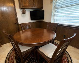 Round rug round heavy wood br akfast table with chairs