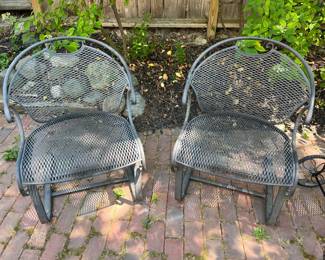 Two of four matching Woodard wrought iron patio chairs.