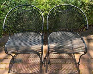 Two of four matching Woodard wrought iron patio chairs.