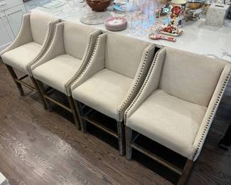 Four beige fabric upholstered counter stools by Gabby.