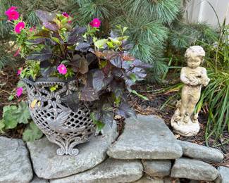 Metal planter with sweet Caroline and petunias; garden statue featuring a child holding rabbits.