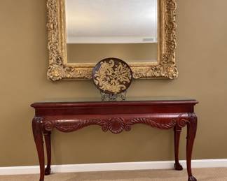 Mahogany console table with glass overlay and ornately framed believed glass mirror (4‘5“ by 3‘8“)