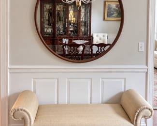 Upholstered roll arm bench and large round wood framed mirror