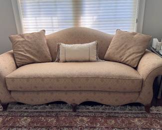 Tan Camelback sofa with curved arms