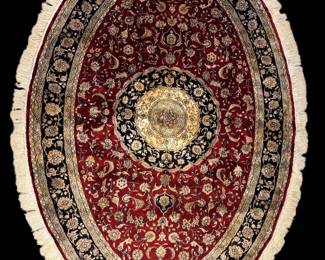 Round burgundy and ivory rug with ornate gold central medallion