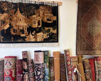 Showroom display featuring an extensive selection of rolled and hanging rugs