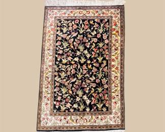 Black floral rug with colorful botanical pattern and ivory border