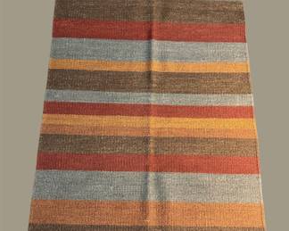 Warm multicolor striped rug in rust, gold, gray, and orange tones