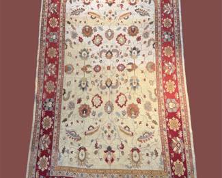 Ivory floral rug with red border and colorful botanical details