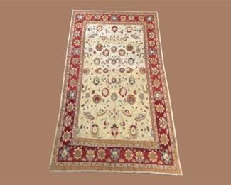 Ivory traditional rug with small repeating motifs and decorative red border