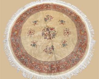 Round ivory and burgundy rug with delicate central medallion