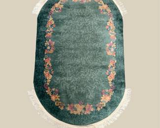 Oval teal rug with decorative floral border
