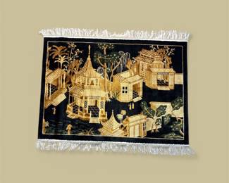 Black pictorial rug featuring an ornate gold village scene