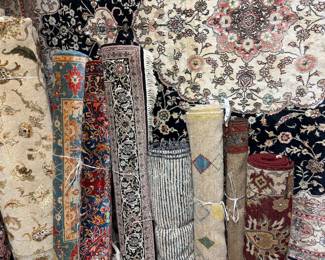 Assorted rolled rugs showcasing intricate floral and traditional designs