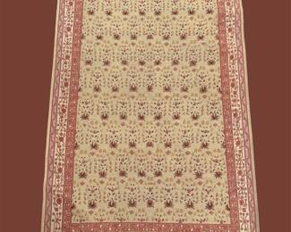 Ivory rug with small repeating dark motifs and red border