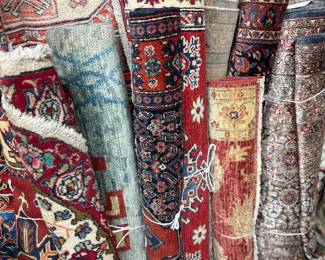 Colorful assortment of rolled handmade rugs in varied patterns and styles