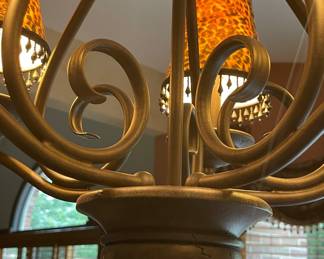 Wrought-iron scroll chandelier with leopard-print lamp shades