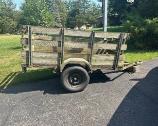 single-axle utility trailer with steel frame, wood stake sides,