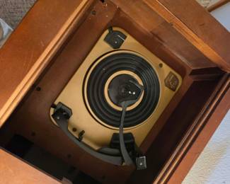 Built-in vintage record player with original turntable and tonearm housed inside a classic wood stereo console. A collectible mid-century audio system for vinyl enthusiasts, available at this Tavares, Florida estate sale hosted by Kinfolk Estate Sales.
