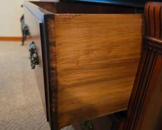 Close-up of a solid wood dresser drawer featuring quality dovetail joinery, carved detailing, and classic craftsmanship. Well-built bedroom furniture available at this Tavares, Florida estate sale hosted by Kinfolk Estate Sales.