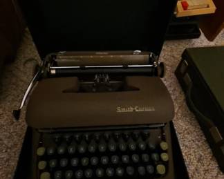Vintage Smith-Corona portable manual typewriter with its original carrying case. A classic writing machine prized by collectors, writers, and vintage office enthusiasts, available at this Tavares, Florida estate sale hosted by Kinfolk Estate Sales.