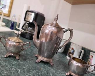 Elegant vintage silver tea service including a coffee pot, sugar bowl, and creamer with timeless traditional styling. A beautiful collectible and entertaining set available at this Tavares, Florida estate sale hosted by Kinfolk Estate Sales.