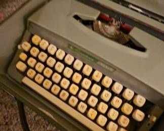 Vintage portable manual typewriter with carrying case, featuring classic mechanical keys and timeless craftsmanship. A wonderful collectible for writers, decorators, and vintage office enthusiasts, available at this Tavares, Florida estate sale hosted by Kinfolk Estate Sales.