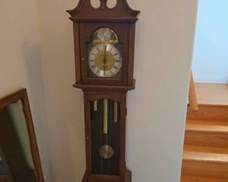 Traditional grandfather clock with a classic wood cabinet, pendulum movement, and elegant dial. A timeless statement piece available at this Tavares, Florida estate sale featuring quality furniture and collectibles, hosted by Kinfolk Estate Sales.