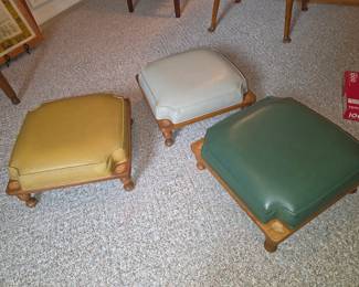 Set of three vintage upholstered footstools featuring solid wood bases, turned legs, and coordinating upholstered cushions. Functional accent furniture perfect for extra seating, footrests, or traditional home décor, available at this Tavares, Florida estate sale hosted by Kinfolk Estate Sales.