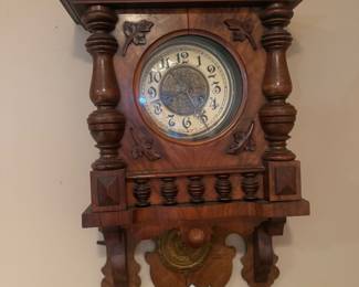 Vintage carved wood wall clock with pendulum.