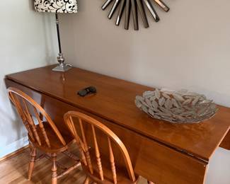 Solid wood drop-leaf dining table with chairs.