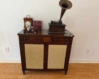 Antique cabinet, antique phonograph, leather bound Charles Dickens books, antique clock