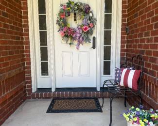 Floral wreath, iron bench and patriotic pillows