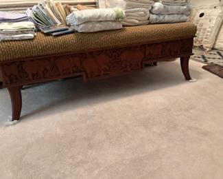 Bench in master bedroom, upholstered with base of carved wood elephants