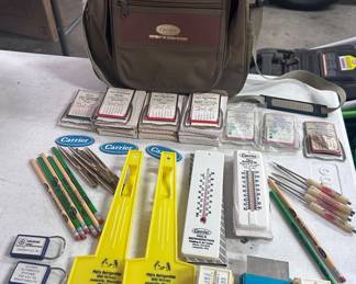 A whole lot of carrier refrigerator ‘leave behind/promotional accessories. Including 19 70s-1980s calendars and mirrors, thermometers, scrapers, pens, pencils and not the large Carriers accessories, carrying bag.
