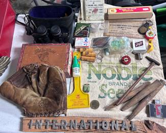 Binoculars in the upper left corner, Winnie the Pooh watch with original box upper right corner, a 1940s Marty Marion (SS for the St Louis Cardinals) three fingered baseball glove in the lower left corner,  International Harvester sign on the bottom and a lot of other miscellaneous items
