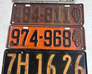 A 1933 California license plate, two 1927 Illinois license plates and one 1975 plate with frame.