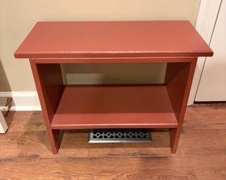 F31 - $40. Small Red Table. Measures 24" wide, 11" deep, 19" tall.