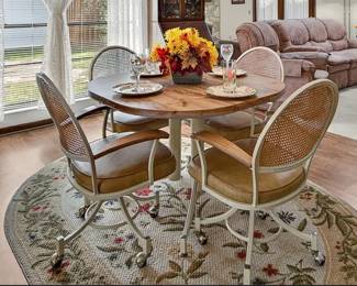 Vintage dining set with round pedestal table and 4 cane back chairs on caster wheels