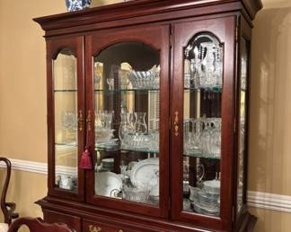China cabinet featuring an arched pediment, glass-front upper display doors and brass-tone hardware.