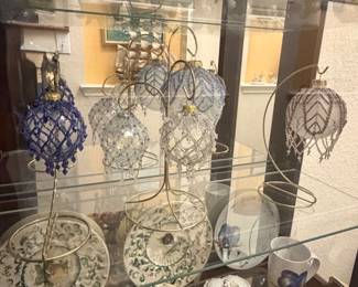 Handcrafted beaded glass ball Christmas ornaments in clear, iridescent, and blue designs.